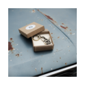 V8 Schlüsselanhänger im Geschenkkarton auf Oldtimer V8 Schlüsselanhänger Messing in Geschenkbox auf blauer, verrosteter Motorhaube.