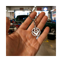 V8 Silber‑Schlüsselanhänger in der Hand vor US‑Muscle‑Car V8‑Schlüsselanhänger aus 925 Sterling‑Silber wird in der Hand vor einer Oldtimer‑Garage mit amerikanischem Muscle‑Car gehalten – ideales Accessoire für Retro‑ und Classic‑Car‑Fans.